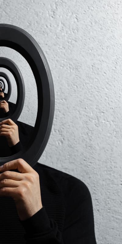 A vertical surrealist portrait of a person in a black turtleneck holding a circular frame that creates an infinite recursive tunnel of their own image.